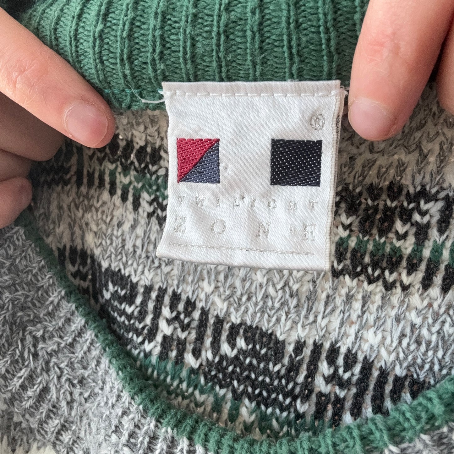 Grauer, grüner und weißer Strickpullover