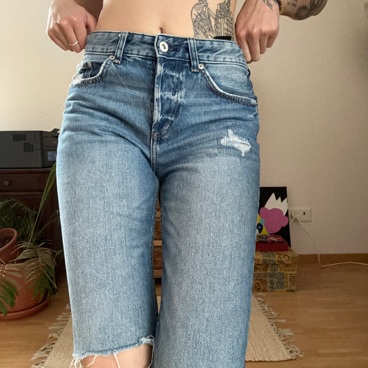 Blue Jeans with one ripped Knee